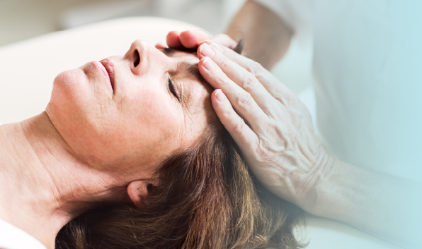 Gently Touching Woman's Forehead representing Reiki